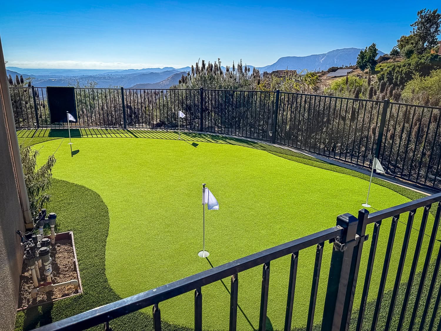 Freshly installed backyard turf putting green and pavers in San Diego, CA